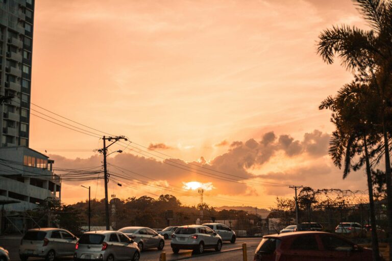Cars driving at sunset in Panama City, showcasing urban landscape and tropical atmosphere.