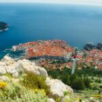 Stunning aerial view of Dubrovnik's historic old town by the Adriatic Sea, showcasing vibrant red rooftops.