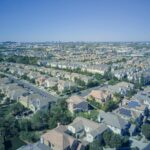 Aerial view of suburban homes in California with solar panels, showcasing sustainable living.