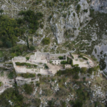 Explore the stunning aerial view of Špiljari Fort amidst Montenegro's rugged landscape, captured by drone.