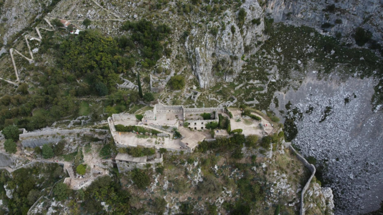 Explore the stunning aerial view of Špiljari Fort amidst Montenegro's rugged landscape, captured by drone.