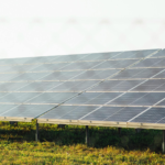 Expansive solar panel array harnessing clean energy in a sunny outdoor field scene.