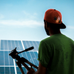 A person in a cap films a solar panel installation, promoting sustainable energy solutions.