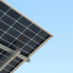 A modern solar panel with a clear blue sky background, highlighting renewable energy.