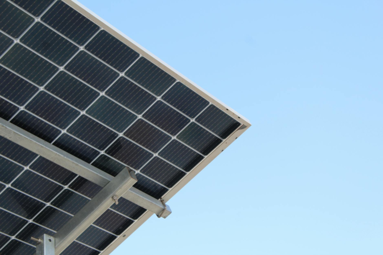 A modern solar panel with a clear blue sky background, highlighting renewable energy.