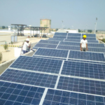 Workers installing solar panels on a rooftop for renewable energy generation.