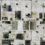 An industrial rooftop with solar panels, viewed from above, ideal for renewable energy concepts.