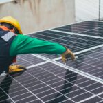 Technician installing solar panels on a rooftop for sustainable energy solutions.