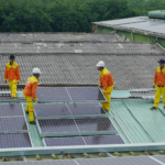Workers installing solar panels on a roof for sustainable energy solutions.