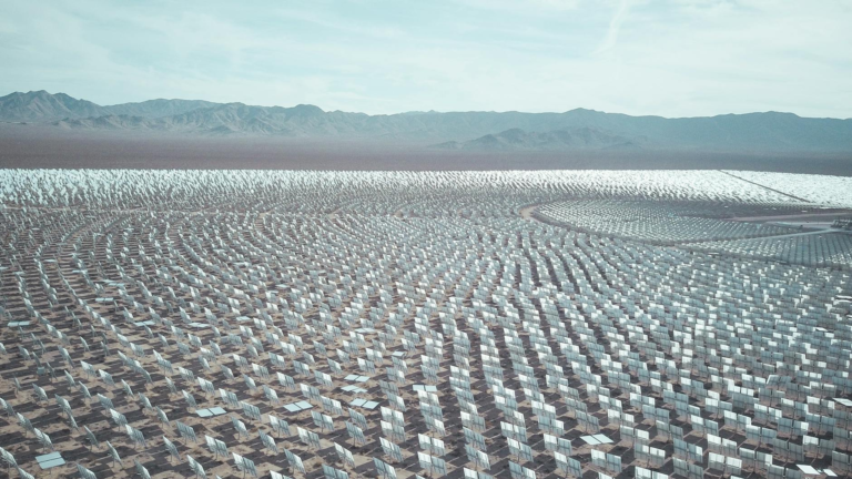 Aerial view of a vast solar farm in a desert setting, capturing renewable energy technology.