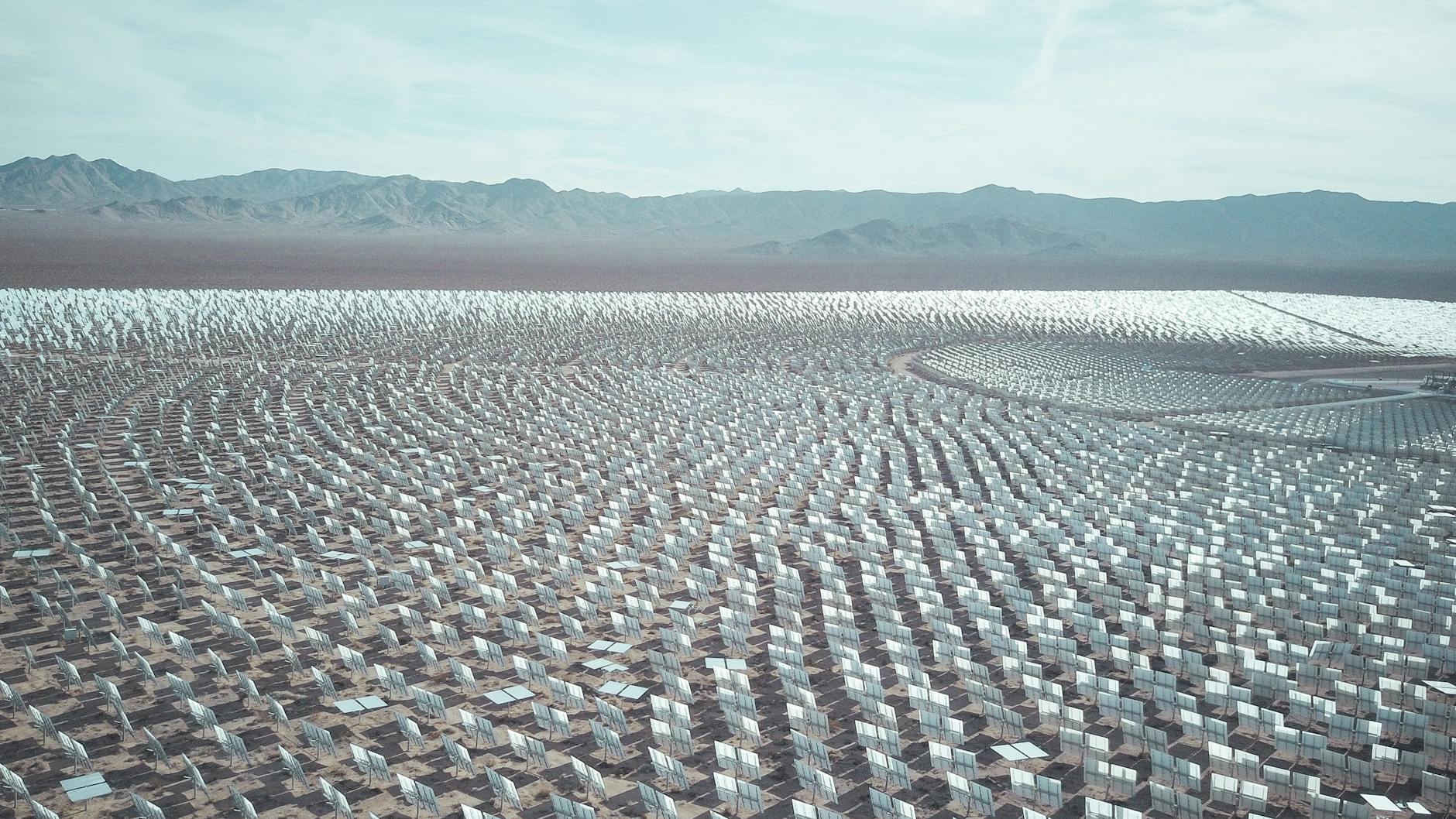 Aerial view of a vast solar farm in a desert setting, capturing renewable energy technology.