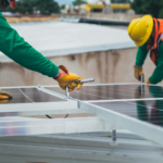 Workers secure solar panels on a rooftop, advancing renewable energy.