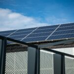 Close-up view of modern solar panels on a rooftop against a clear blue sky, representing clean energy.