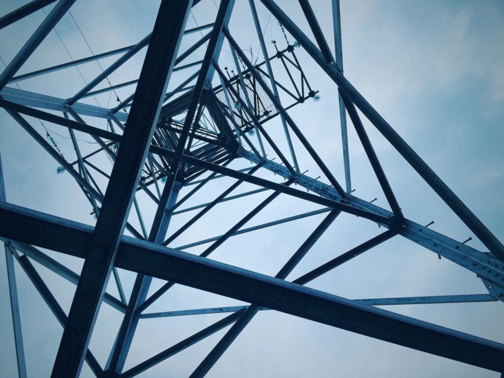 Low angle shot of a steel electricity tower against a clear sky.