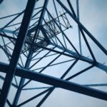 Low angle shot of a steel electricity tower against a clear sky.