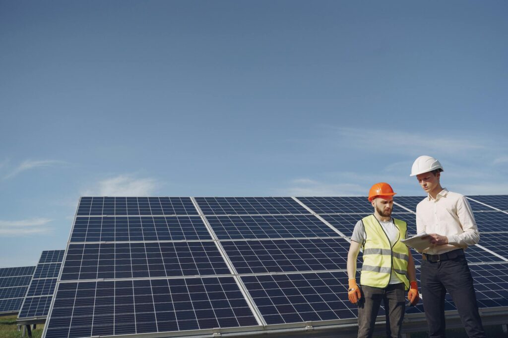 Two engineers inspecting a solar panel array to ensure efficiency and sustainability.