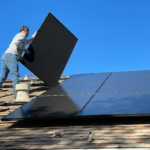 A worker installs solar panels on a sunny day, highlighting renewable energy solutions.