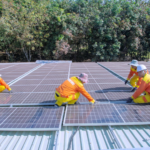 Team of workers installing solar panels on a sunny day, promoting renewable energy and sustainability.