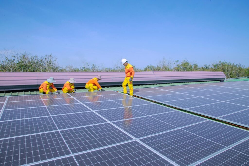 Workers install solar panels on a rooftop, promoting renewable energy and sustainability.