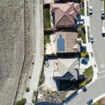 Top-down aerial view of a suburban neighborhood in Dublin, California with solar panels and parked cars.