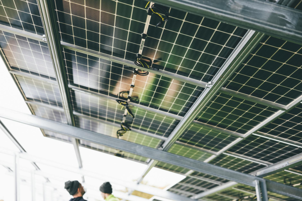 Close-up of solar panels being installed outdoors with technicians visible.