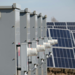 Close-up of electrical boxes and solar panels harnessing solar energy outdoors.