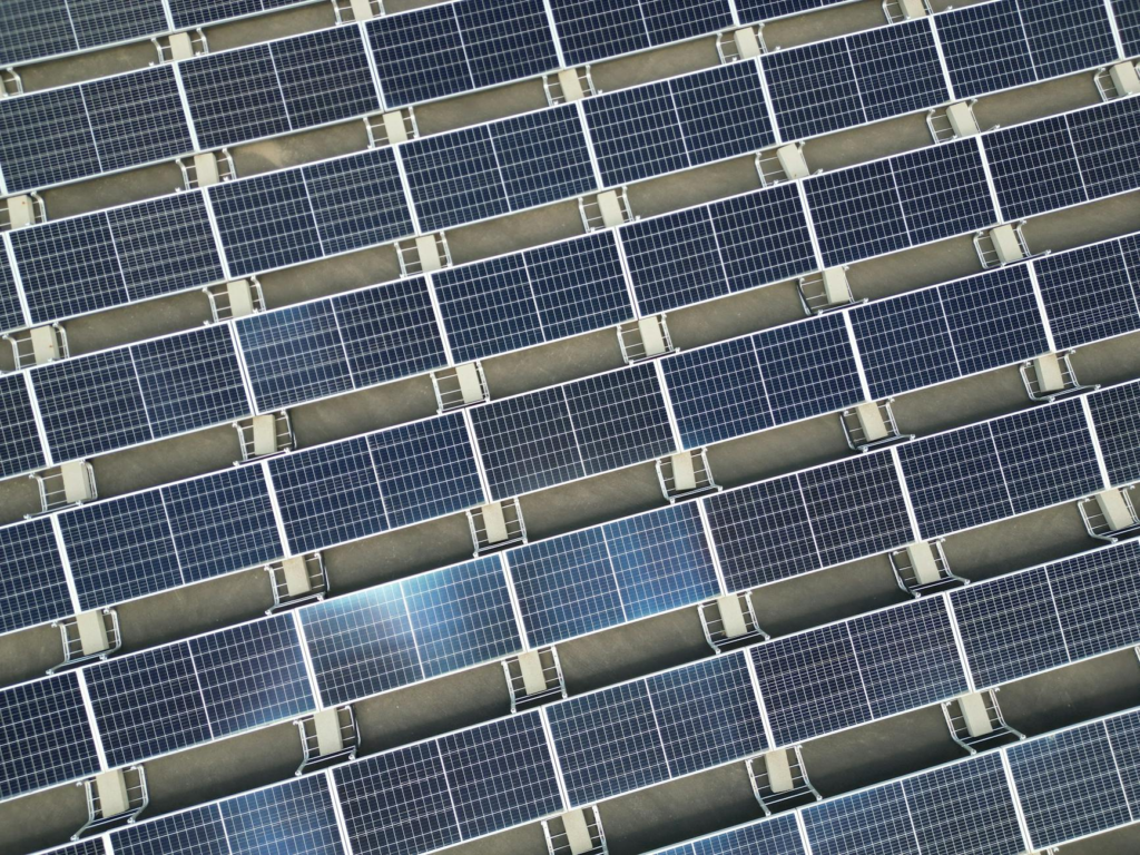 Array of solar panels in grid layout viewed from above promoting renewable energy