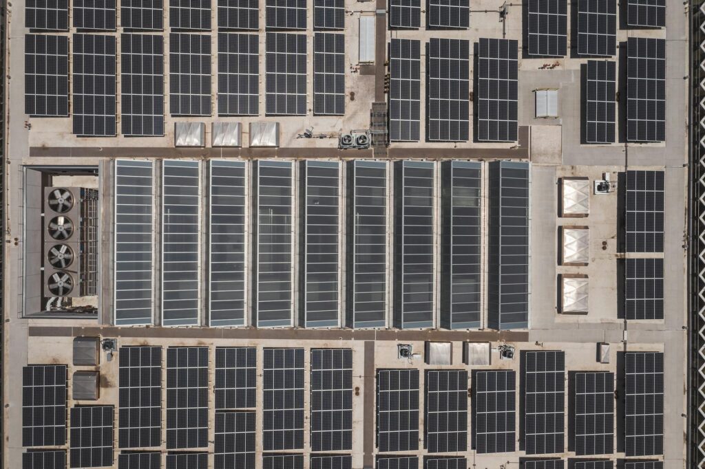 High-angle drone shot of rooftop solar panels showcasing renewable energy technology.