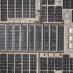 High-angle drone shot of rooftop solar panels showcasing renewable energy technology.