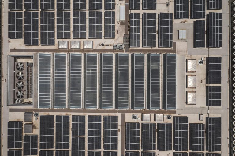 High-angle drone shot of rooftop solar panels showcasing renewable energy technology.