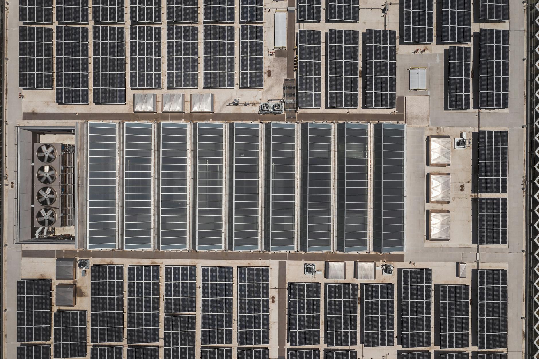 High-angle drone shot of rooftop solar panels showcasing renewable energy technology.