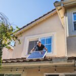 Solar technician installing photovoltaic panels on a sunny rooftop.