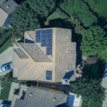 Top-down aerial view of a house with solar panels, showcasing modern renewable energy solutions.