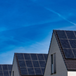Contemporary homes featuring solar panels under a bright blue sky promoting renewable energy.