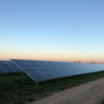 Solar panels in a field at dusk near Andria, Italy, capturing renewable energy.