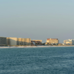 Sunset view of Destin, FL beachfront with modern architecture and serene ocean.