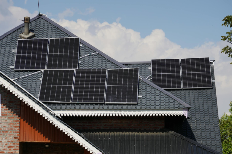 Rooftop solar panels on a house in Srinagar against a blue sky backdrop.