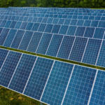 High angle pole mounted solar energy trackers installed on green field in solar power station