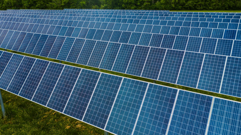High angle pole mounted solar energy trackers installed on green field in solar power station