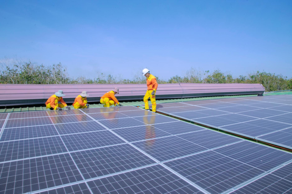 Workers install solar panels on a rooftop, promoting renewable energy and sustainability.