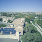 Aerial shot of a suburban neighborhood with solar panels on rooftops, showcasing clean energy.
