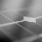 Detailed monochrome close-up of a solar panel surface showing texture and grid pattern.