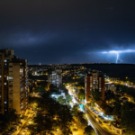 A stunning cityscape view illuminated by lightning on a stormy night.