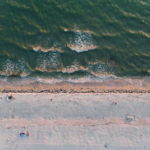 A stunning aerial view of Sarasota Beach, Florida featuring sandy shores and gentle waves at sunset.