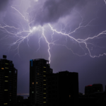 Stunning view of lightning bolts illuminating a cityscape at night, creating a dramatic and powerful scene.