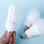Close-up of energy-saving CFL and LED light bulbs on a blue background, showcasing eco-friendly lighting solutions.