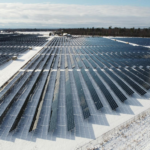 Aerial view of a solar farm in snowy Arnprior, Ontario, showcasing renewable energy.