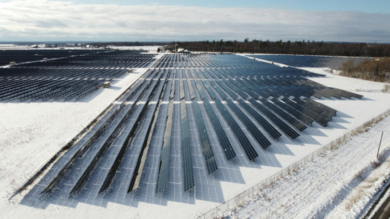 Aerial view of a solar farm in snowy Arnprior, Ontario, showcasing renewable energy.