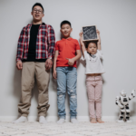 Indoor portrait of a happy family with two children and a robot, showcasing quality time together.